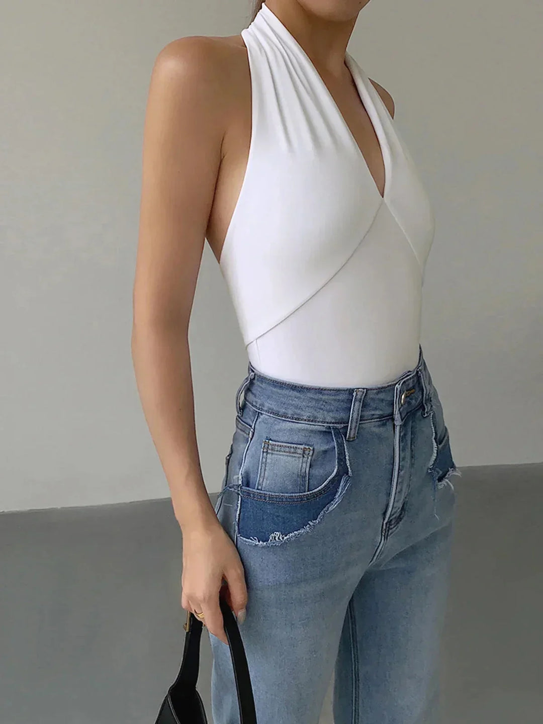 Top femme dos-nu blanc, en coton doux, avec un croisement avant et une coupe moderne, parfait pour le printemps.