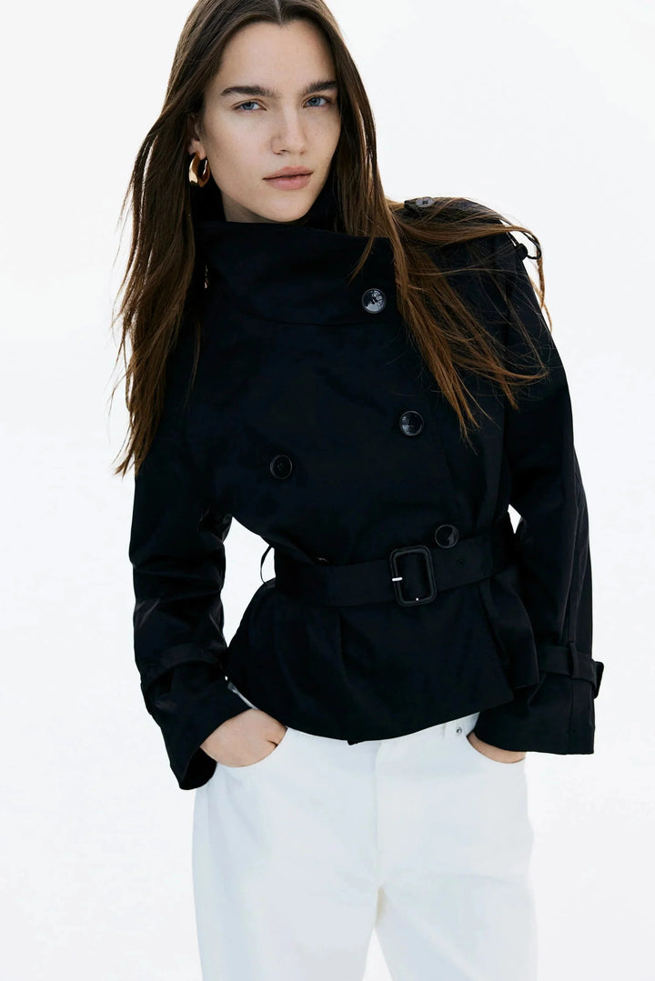 Trench-coat femme avec col montant, ceinture nouée et coupe ajustée, en tissu résistant, parfait pour les jours frais.
