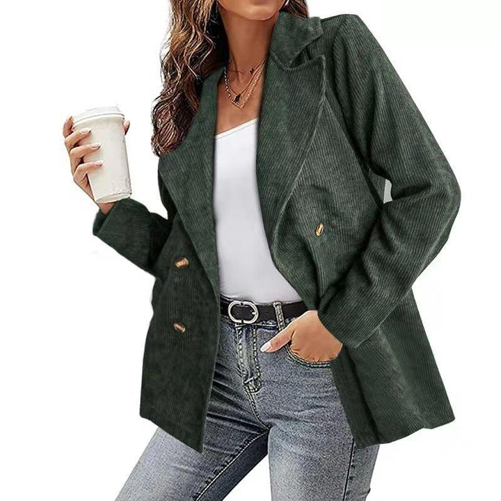 Giacca donna verde scuro in velluto a coste, doppio petto, abbinata a jeans e top bianco. Moda autunnale casual elegante.