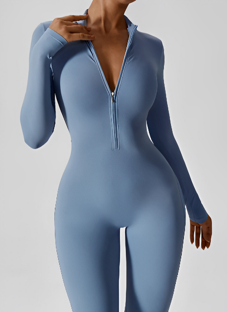 Tuta sportiva donna blu, maniche lunghe, zip frontale, design aderente. Abbigliamento fitness elegante e moderno per allenamenti e yoga.