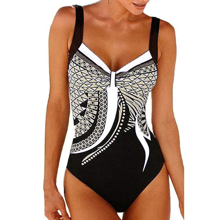 Costume intero donna nero con motivo geometrico bianco e dorato, spalline larghe, design elegante. Perfetto per spiaggia e piscina.