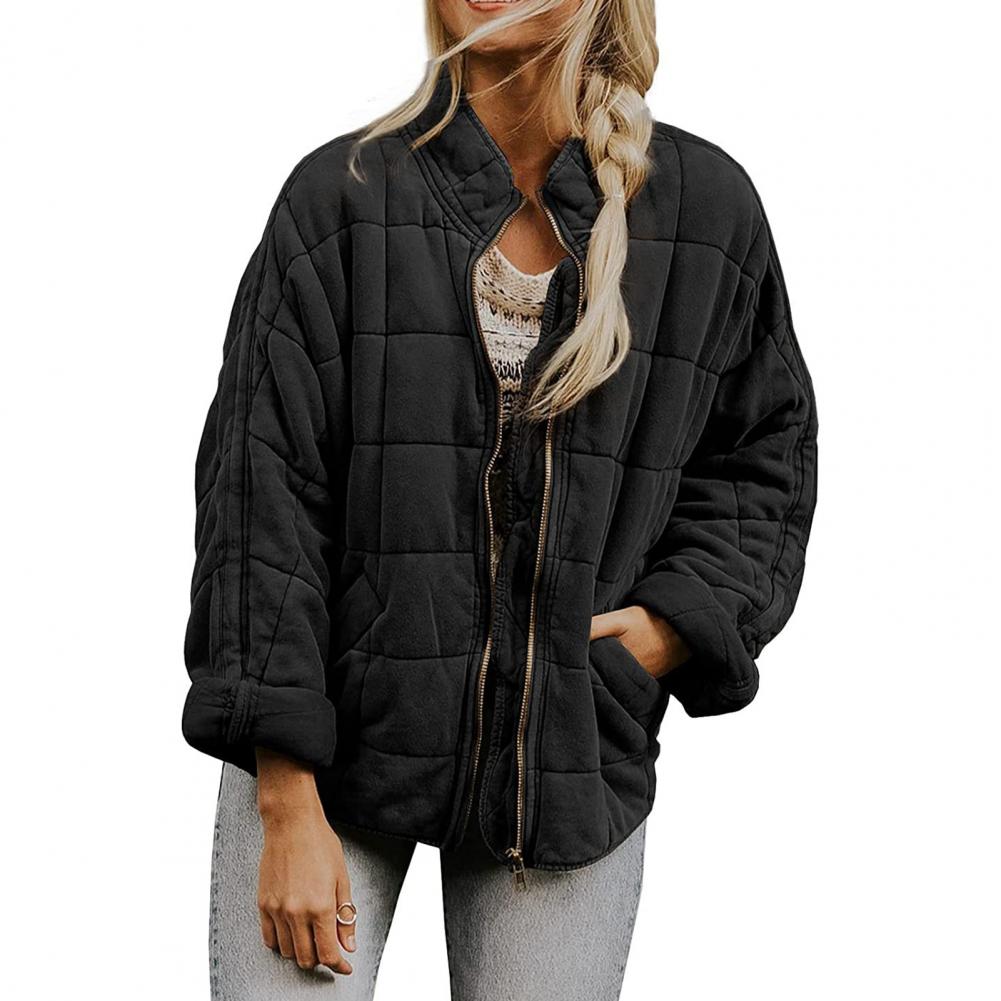 Giacca trapuntata nera da donna, stile casual, con zip frontale, maniche lunghe, indossata su maglia bianca, perfetta per l'autunno.
