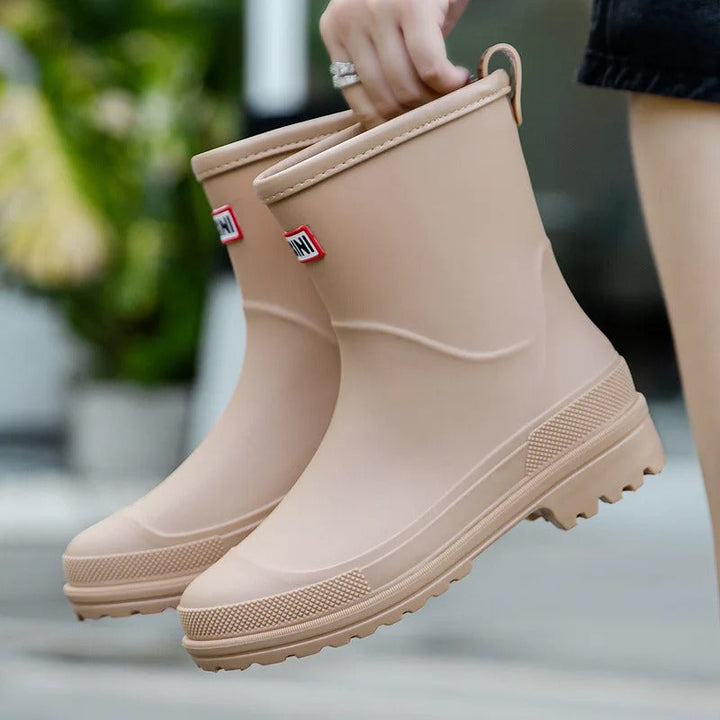 Stivali da pioggia beige in gomma, design moderno, suola antiscivolo, ideali per giornate piovose. Scarpe impermeabili per donna, moda autunno.