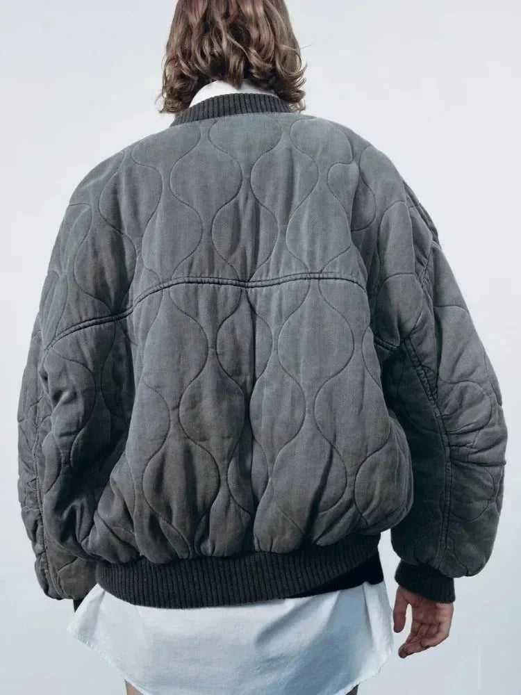 Veste bomber femme oversize matelassée gris avec boutons-pression, conçue pour un style décontracté.