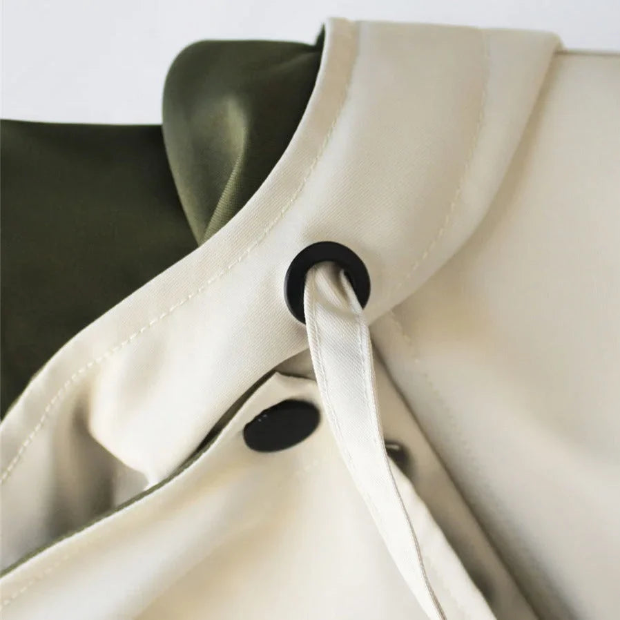Veste coupe-vent blanche pour femme, avec capuche amovible, coupe sportive et poches pratiques.