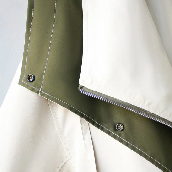 Veste coupe-vent blanche pour femme, avec capuche amovible et poches pratiques pour les activités extérieures.