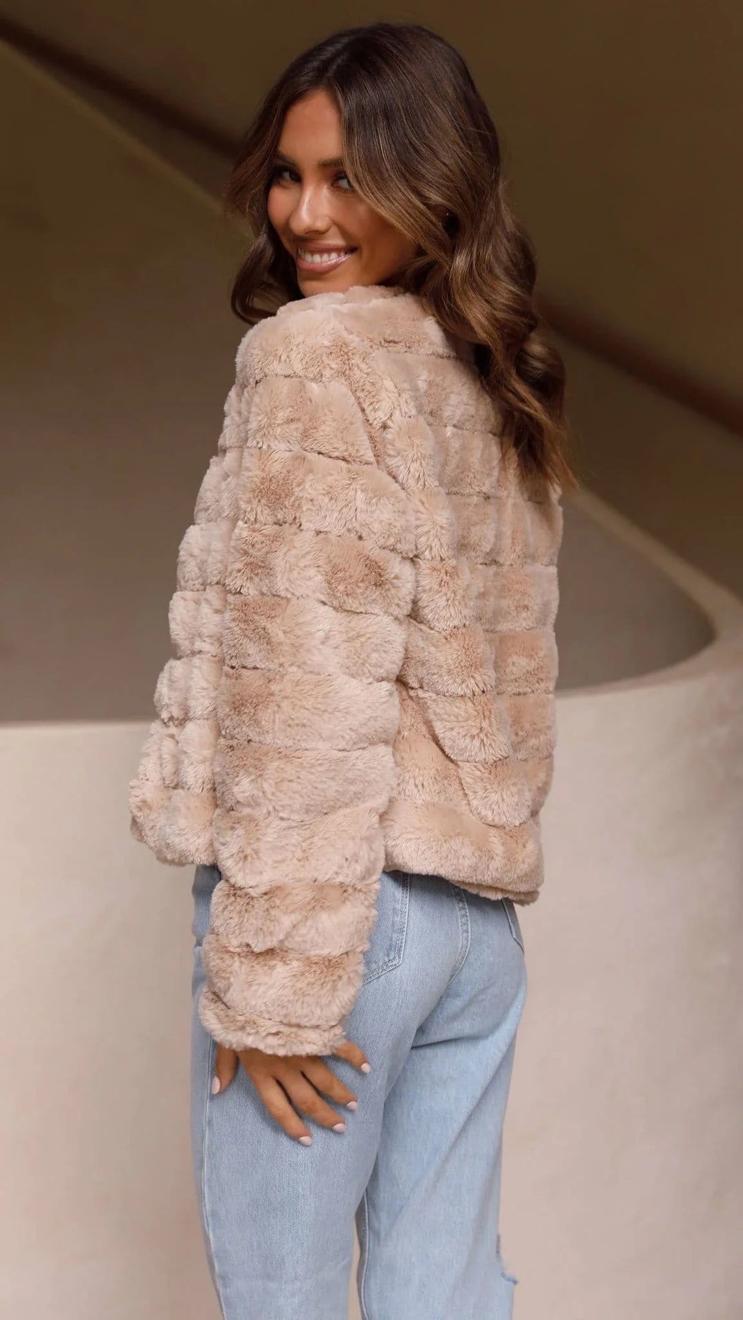 Veste courte femme en fausse fourrure, col ouvert, matière douce, design polyvalent pour diverses tenues.