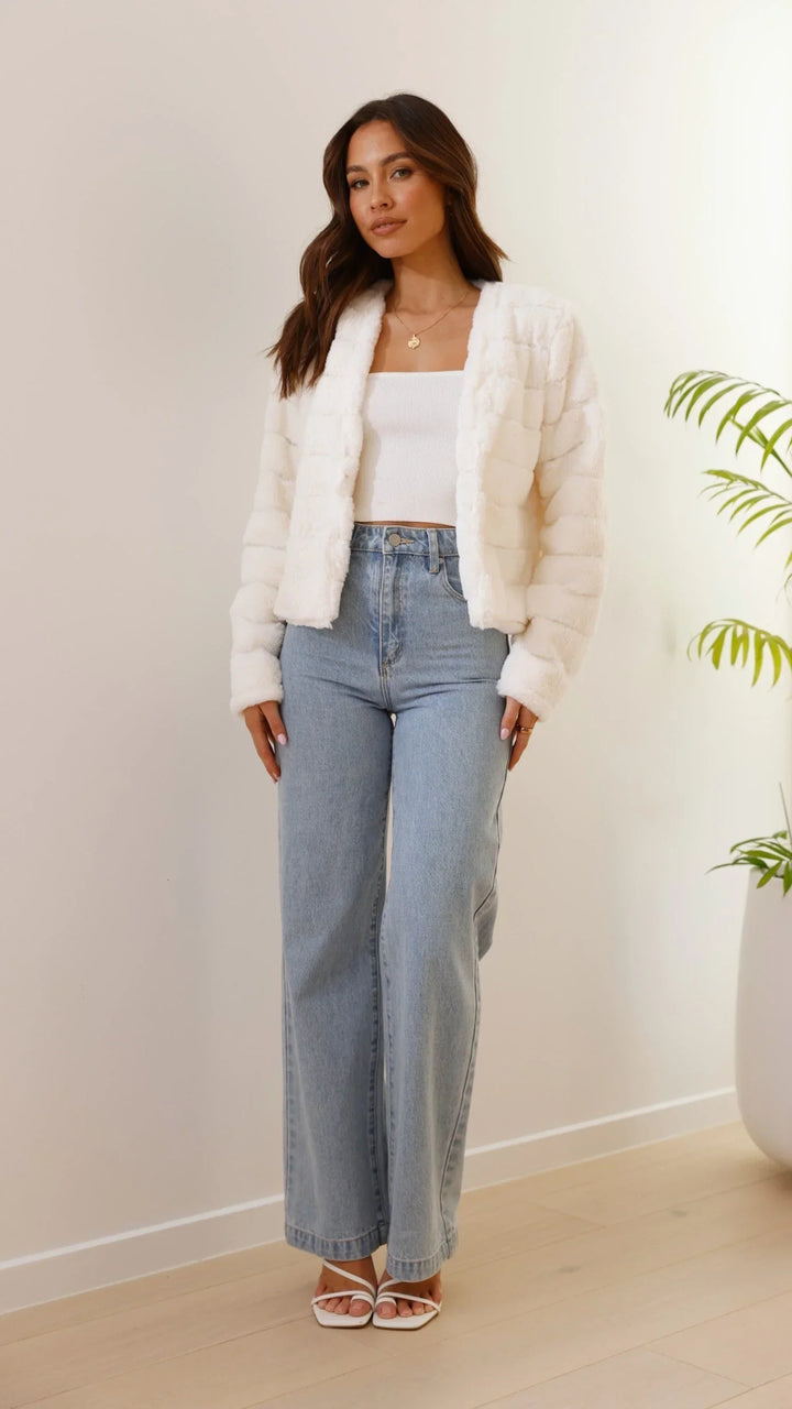 Veste courte femme en fausse fourrure blanche avec col ouvert, douce et chaude, parfaite pour les saisons intermédiaires.