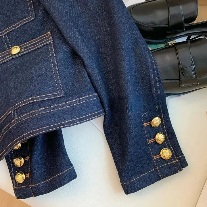 Veste en denim bleu foncé pour femme, coupe classique, avec boutons dorés et en coton robuste.