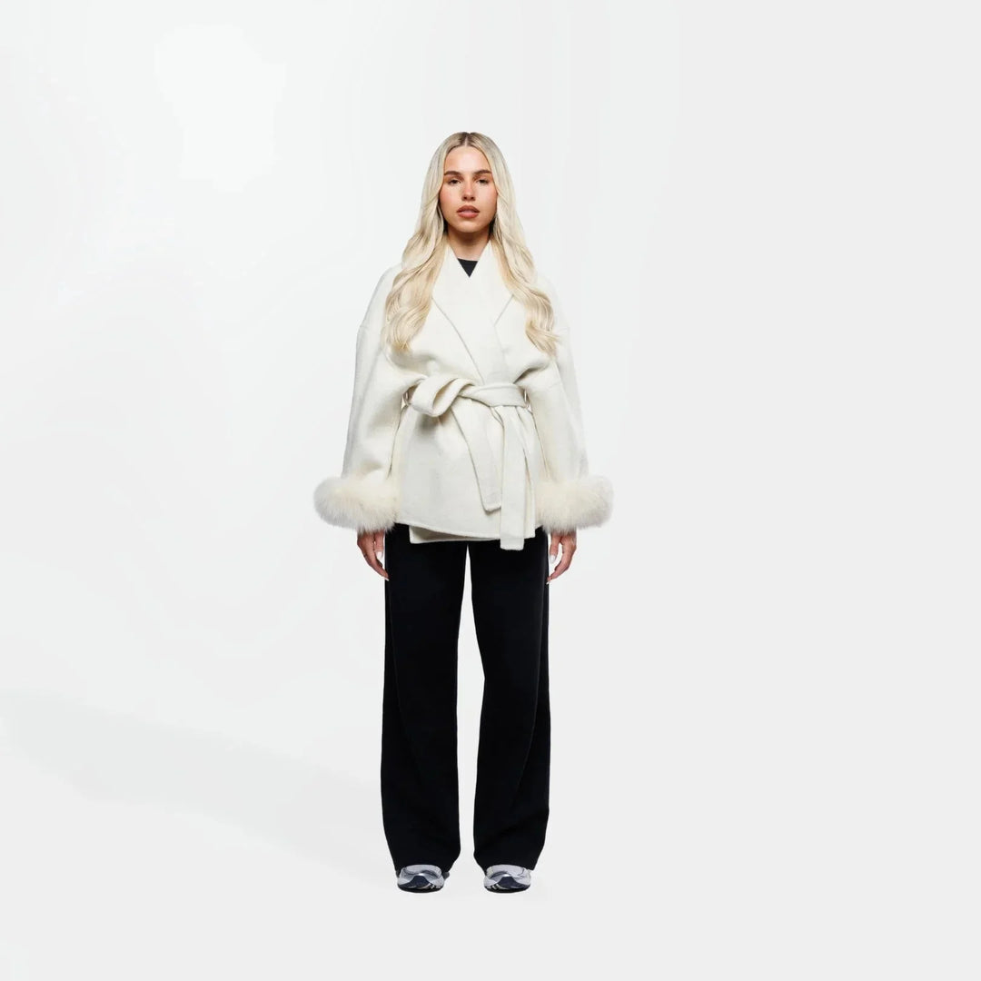 Veste blanche pour femme ceinturée, manches en fourrure synthétique, idéale pour un look élégant et confortable.