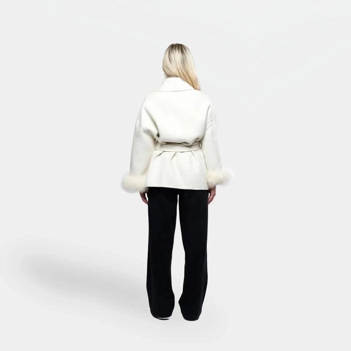 Veste blanche pour femme, ceinturée, avec manches en fourrure synthétique amovibles.