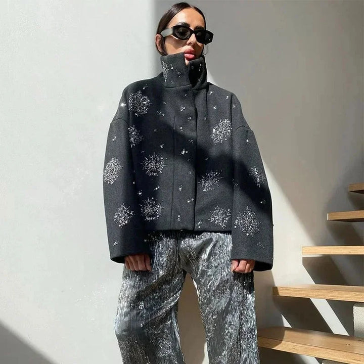 Veste femme gris col montant, broderie, en tissu fluide, avec manches chauve-souris larges.