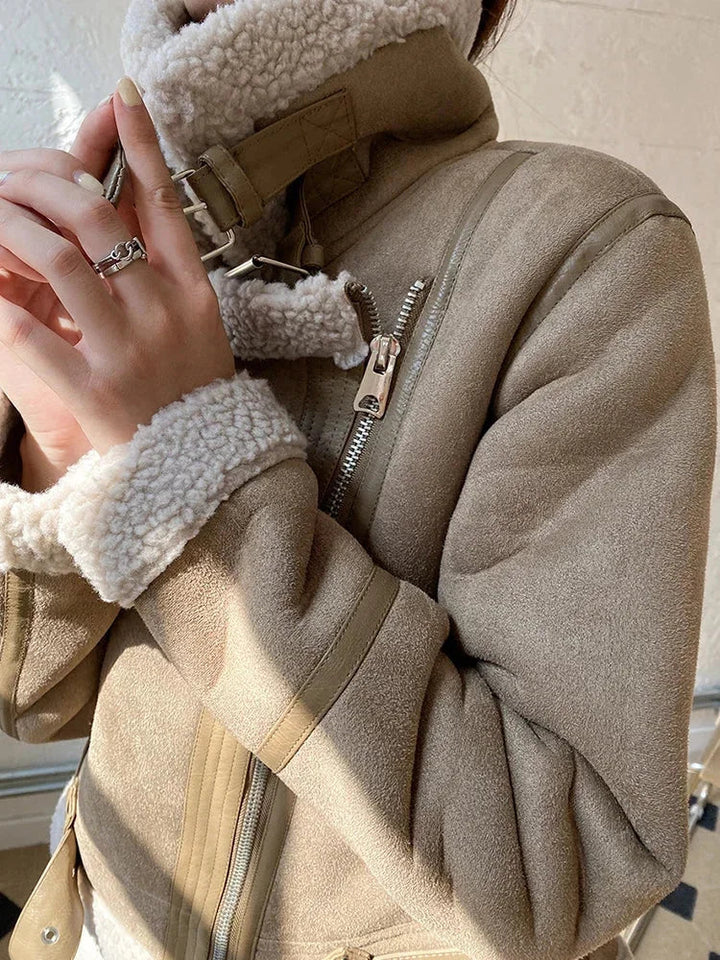 Veste femme en suédine beige avec doublure effet mouton et poches pratiques, parfaite pour les journées fraîches.