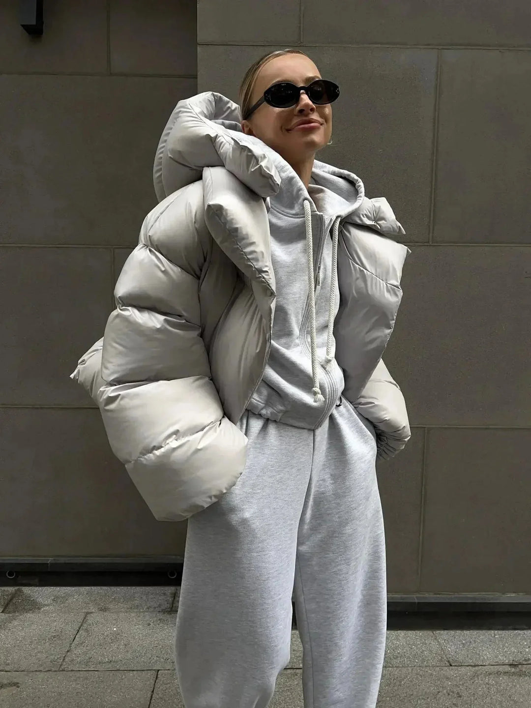 Doudoune oversize grise pour femme avec col montant, en matériau chaud et confortable, idéale pour les journées fraîches.