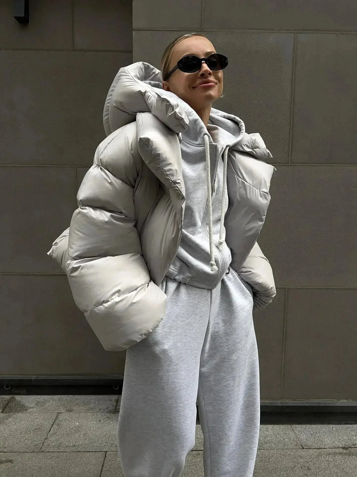 Doudoune oversize grise pour femme avec col montant, en matériau chaud et confortable, idéale pour les journées fraîches.