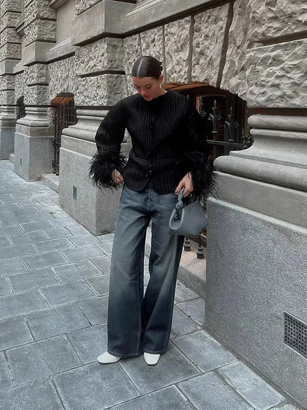 Veste noire femme avec manches en plumes et coupe moderne.