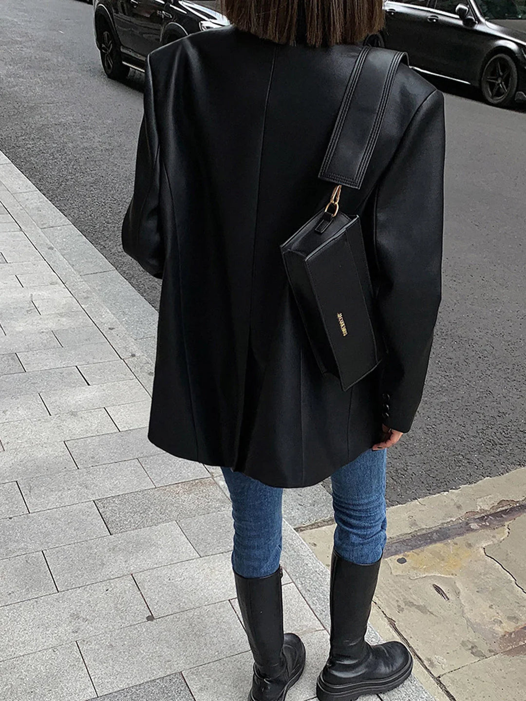Veste surdimensionnée en simili cuir noir pour femme avec col moderne et style décontracté.