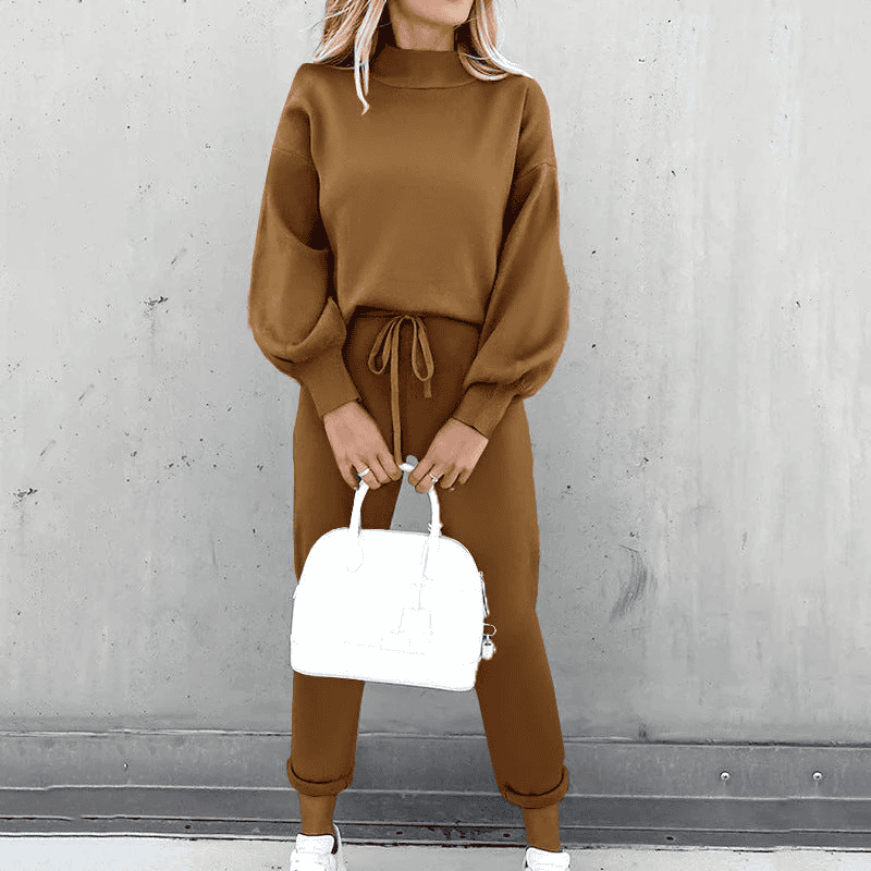 Donna con tuta marrone a maniche lunghe, pantaloni con coulisse, borsa bianca e sneakers. Moda casual autunnale, abbigliamento donna elegante.